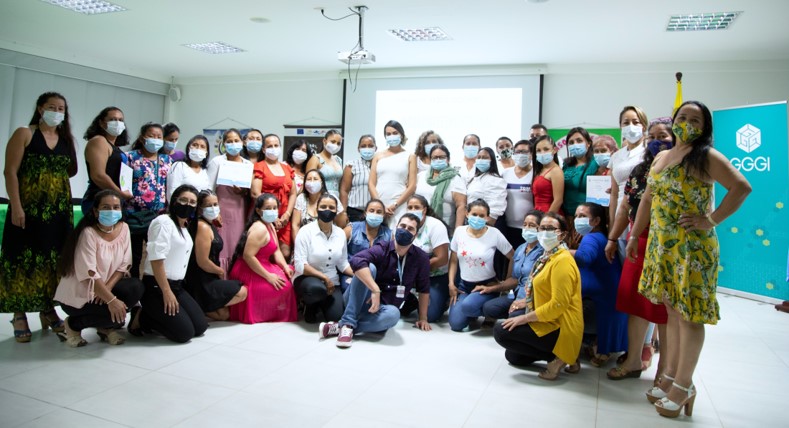 Group of 33 women wearing face masks holding diplomas and posing for the camera